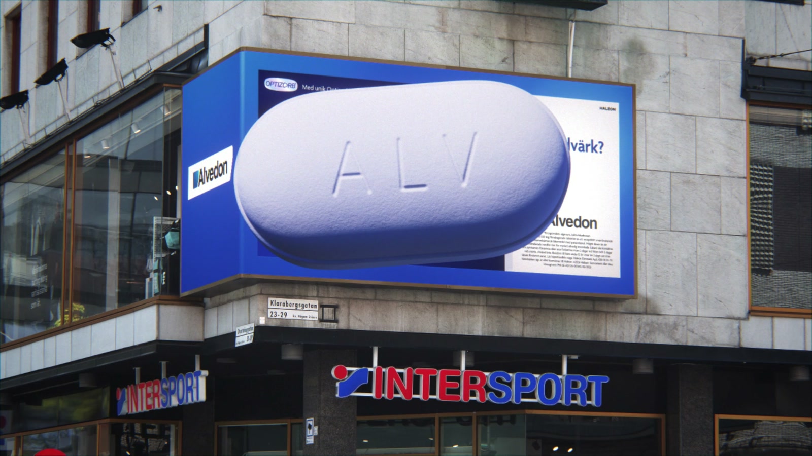 An oversized white Alvedon tablet extending beyond a blue corner display